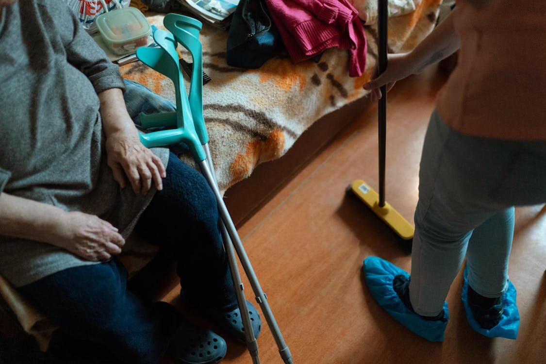 Friendly home carer chatting with an older woman in her living room